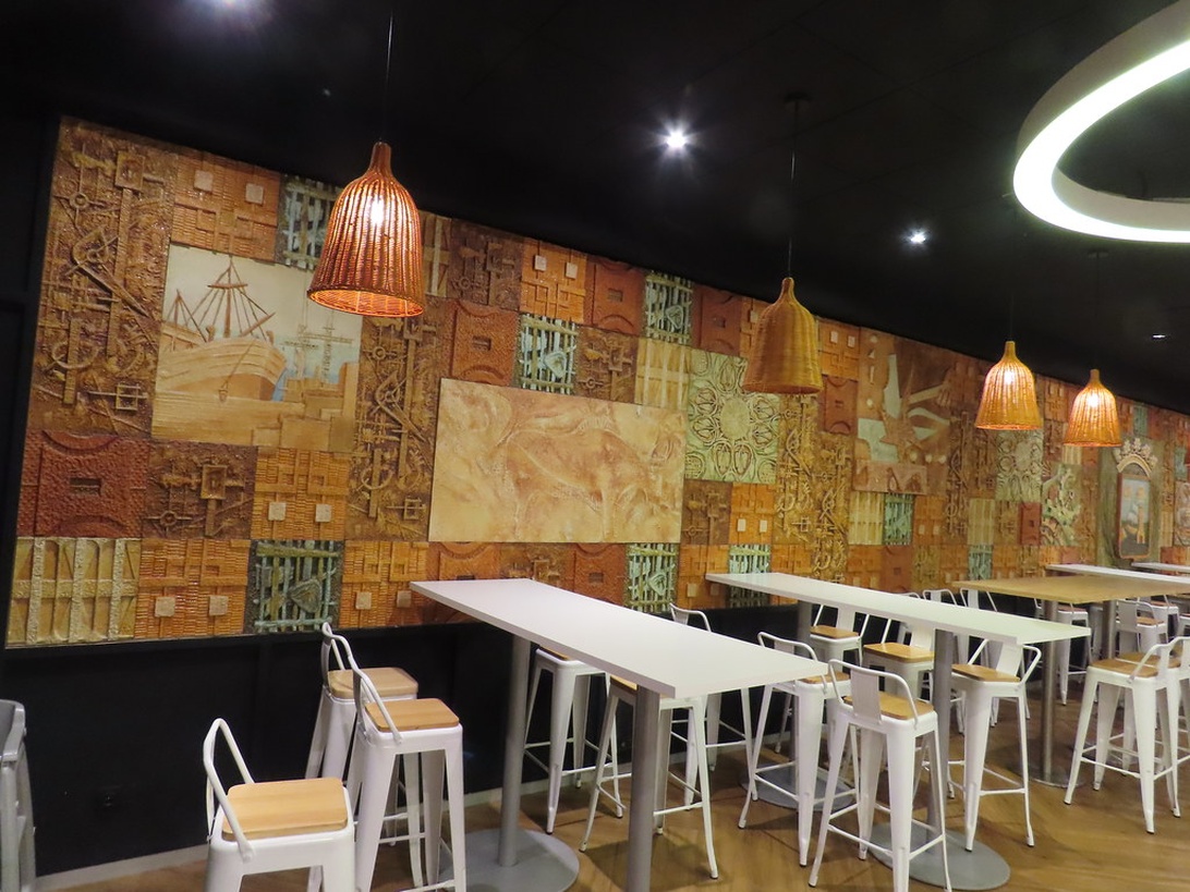 Modernes Interieur eines renovierten Cafés mit kunstvoller Wandgestaltung und stilvollen Hängeleuchten.